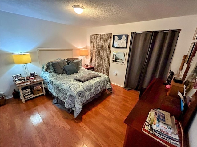 bedroom featuring hardwood / wood-style flooring and a textured ceiling