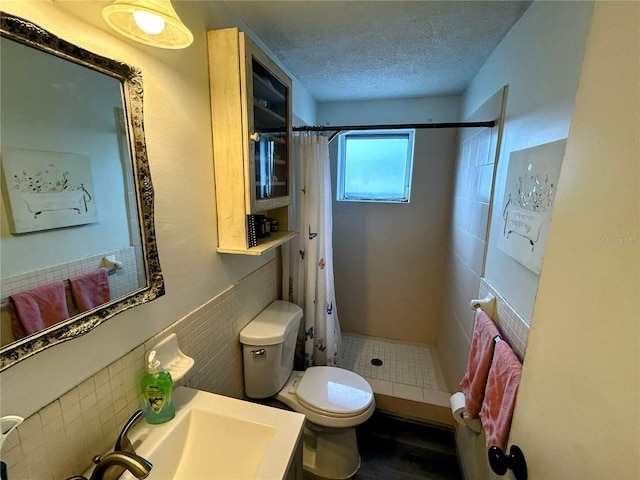 bathroom with curtained shower, sink, a textured ceiling, and toilet