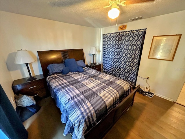 bedroom featuring wood-type flooring, a textured ceiling, and ceiling fan