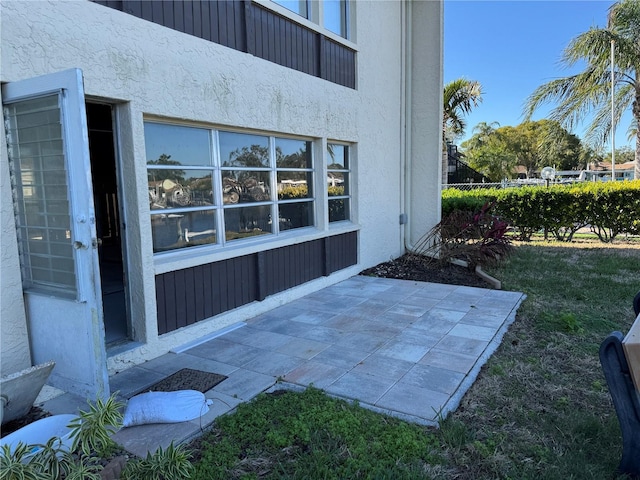 entrance to property featuring a yard and a patio