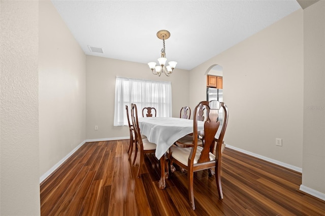 dining area featuring a chandelier and dark wood-type flooring