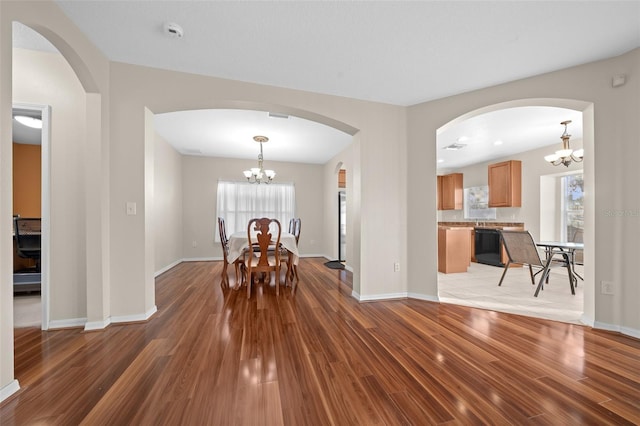 unfurnished dining area featuring hardwood / wood-style flooring and a chandelier