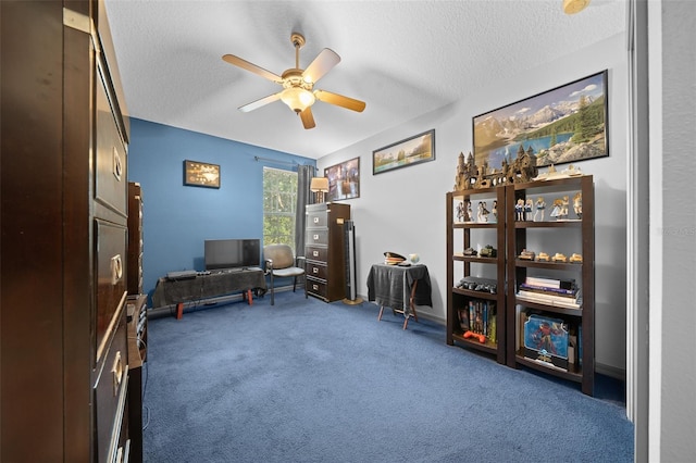 sitting room with ceiling fan, dark carpet, and a textured ceiling