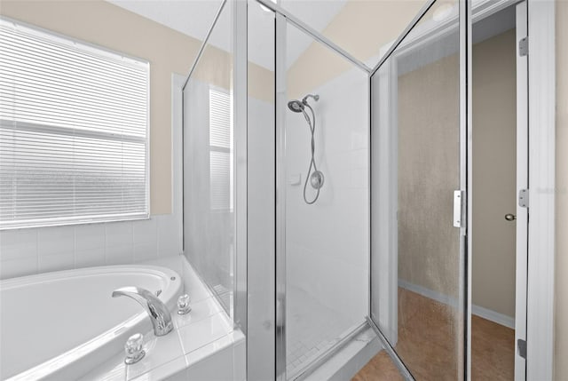 bathroom featuring separate shower and tub