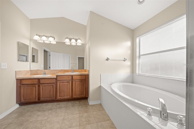 bathroom featuring tile patterned flooring, vanity, lofted ceiling, and tiled bath