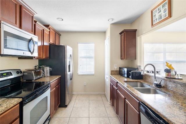 kitchen with sink, light tile patterned flooring, and appliances with stainless steel finishes