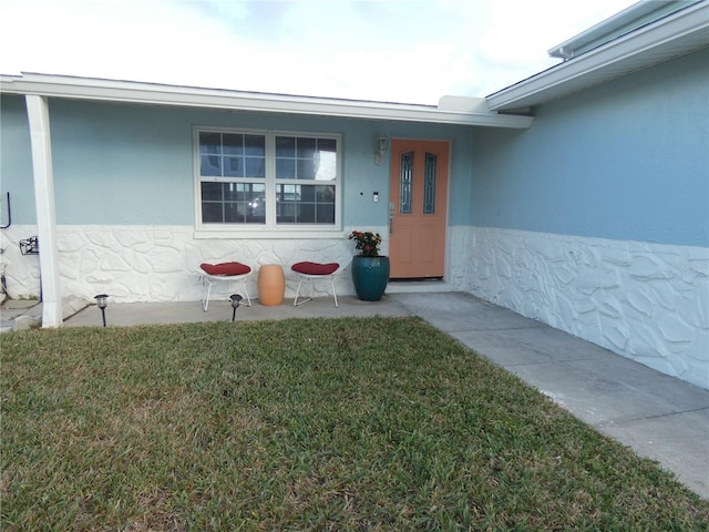 property entrance with a lawn