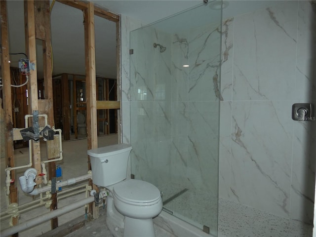 bathroom featuring tiled shower and toilet