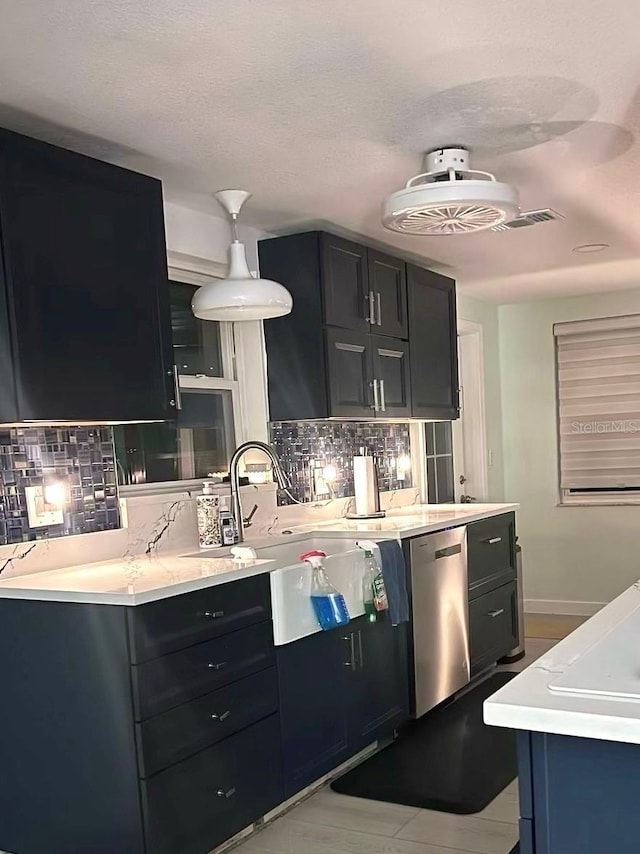 kitchen with stainless steel dishwasher, light tile patterned floors, sink, and tasteful backsplash