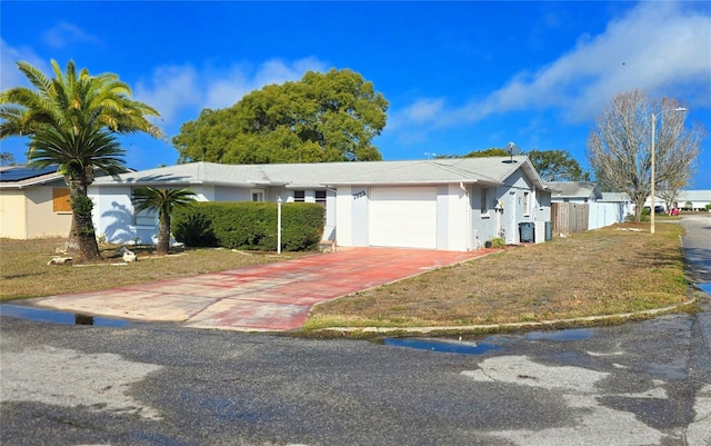 single story home featuring a front yard, central AC unit, and a garage