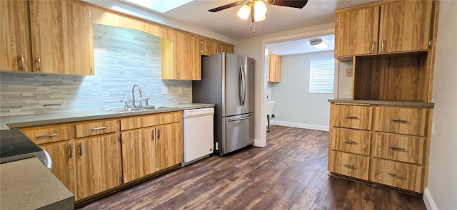 kitchen featuring backsplash, white dishwasher, dark wood-type flooring, sink, and stainless steel refrigerator