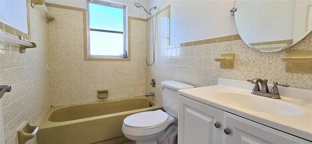 full bathroom with tiled shower / bath combo, toilet, tile walls, and vanity