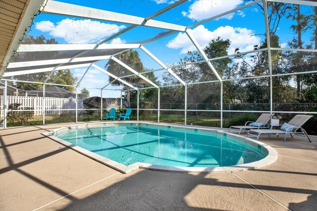 view of pool with a patio and glass enclosure