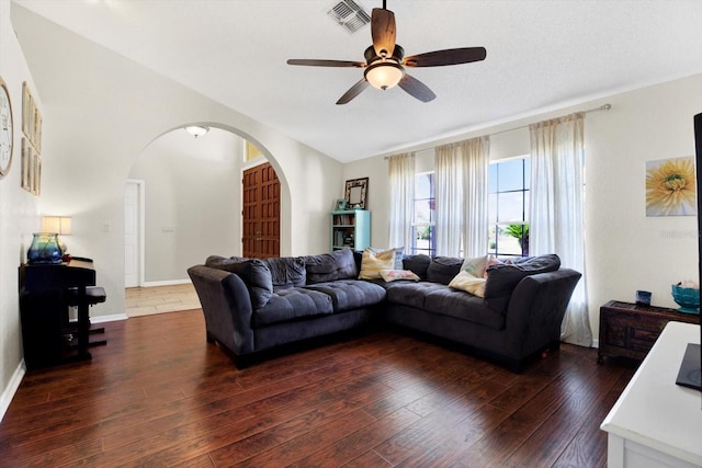 living room featuring a textured ceiling, ceiling fan, dark hardwood / wood-style flooring, and vaulted ceiling