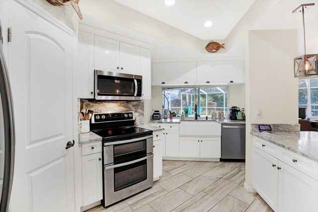 kitchen featuring stainless steel appliances, white cabinetry, hanging light fixtures, and sink