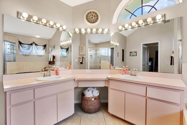 bathroom with tile patterned floors, vanity, and lofted ceiling