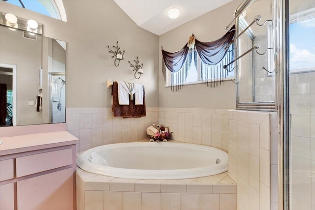 bathroom with plus walk in shower, vanity, plenty of natural light, and lofted ceiling