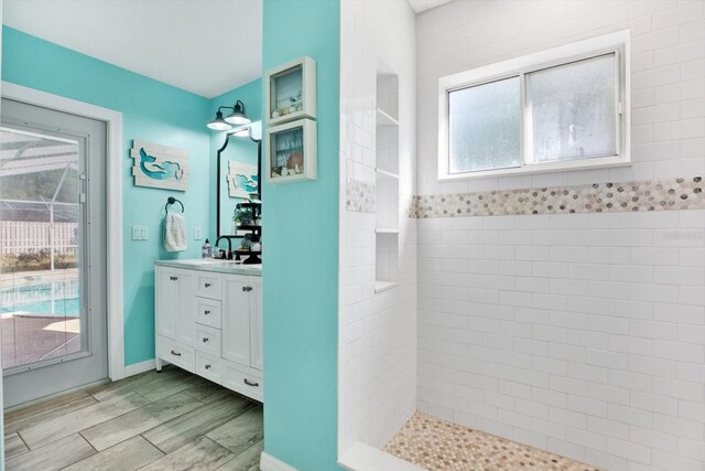 bathroom featuring a tile shower and vanity