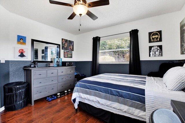 bedroom with ceiling fan, dark hardwood / wood-style flooring, and a textured ceiling