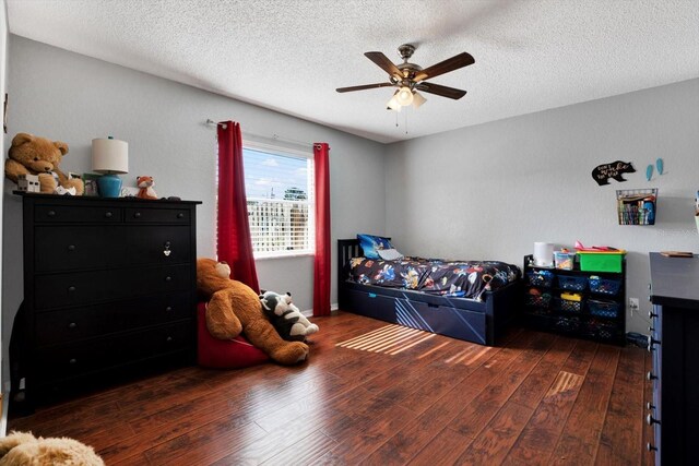 bedroom featuring a textured ceiling, dark hardwood / wood-style flooring, and ceiling fan