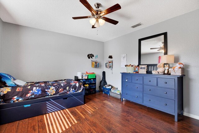 bedroom featuring a textured ceiling, ceiling fan, and dark wood-type flooring