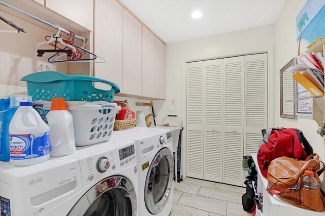 laundry area featuring washer and dryer and cabinets