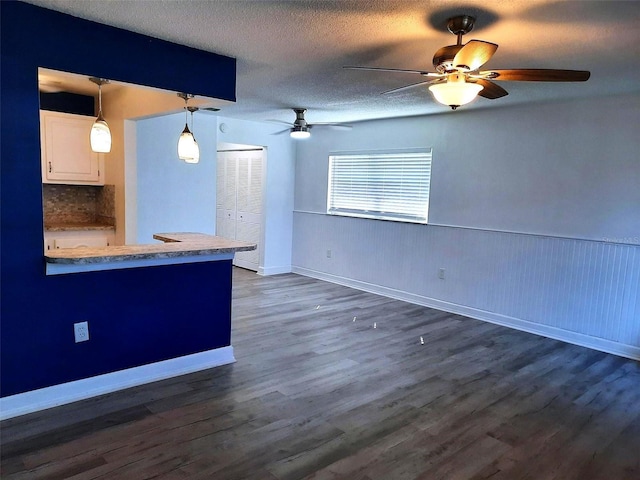 kitchen featuring pendant lighting, dark hardwood / wood-style flooring, white cabinets, and a textured ceiling