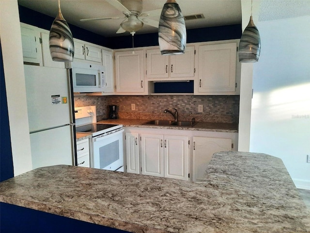 kitchen with white appliances, backsplash, sink, hanging light fixtures, and white cabinetry