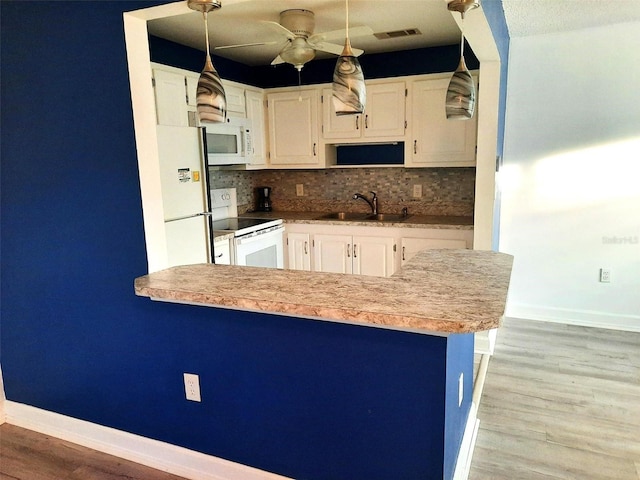 kitchen with decorative backsplash, white appliances, white cabinets, and sink