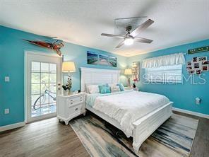 bedroom featuring hardwood / wood-style floors, ceiling fan, and access to exterior