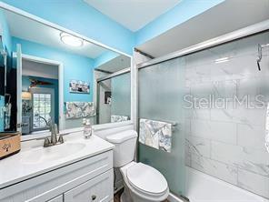 bathroom with vanity, toilet, and a shower with door