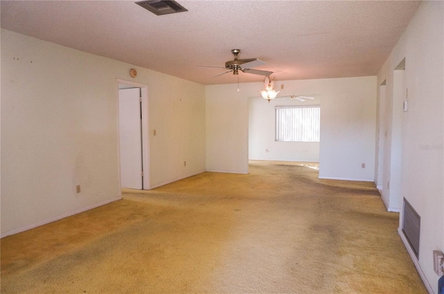 carpeted spare room featuring ceiling fan and a textured ceiling