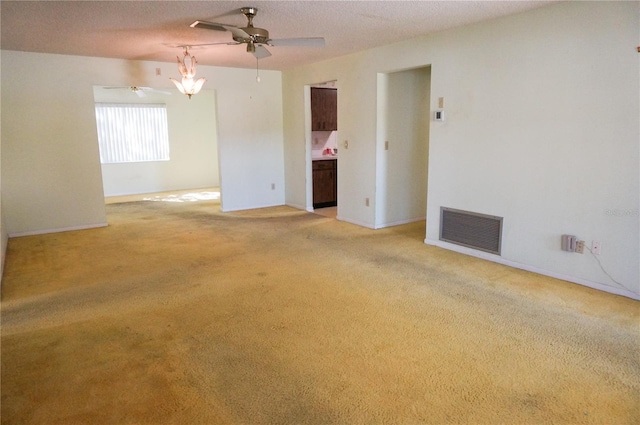 spare room featuring light colored carpet and a textured ceiling