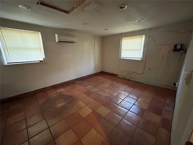 unfurnished room featuring a wall mounted air conditioner and tile patterned floors