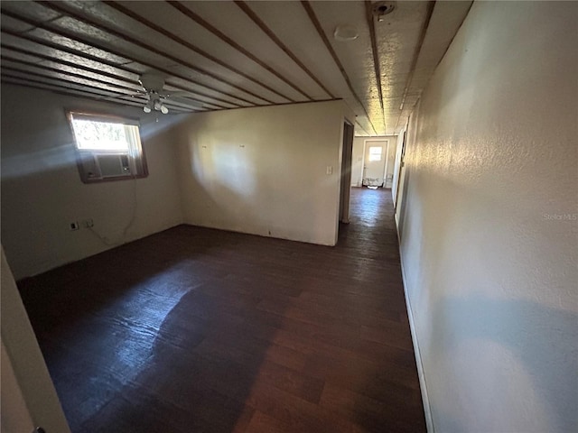 empty room featuring cooling unit and dark hardwood / wood-style floors