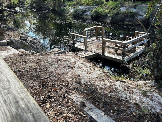 view of yard featuring a dock and a water view