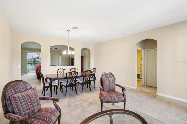 dining room featuring light colored carpet and a chandelier