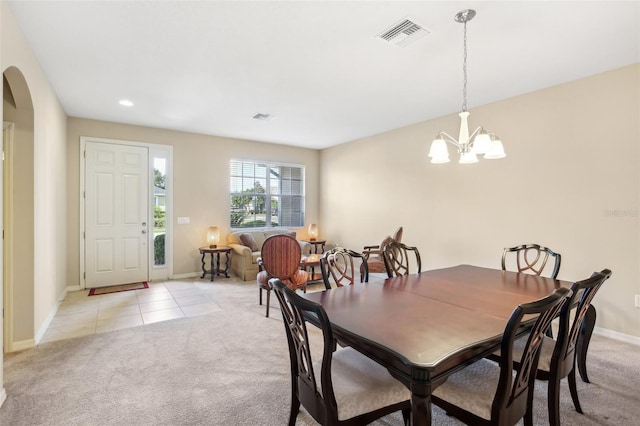 carpeted dining space featuring a chandelier