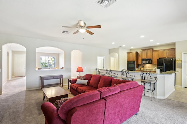 living room featuring ceiling fan with notable chandelier