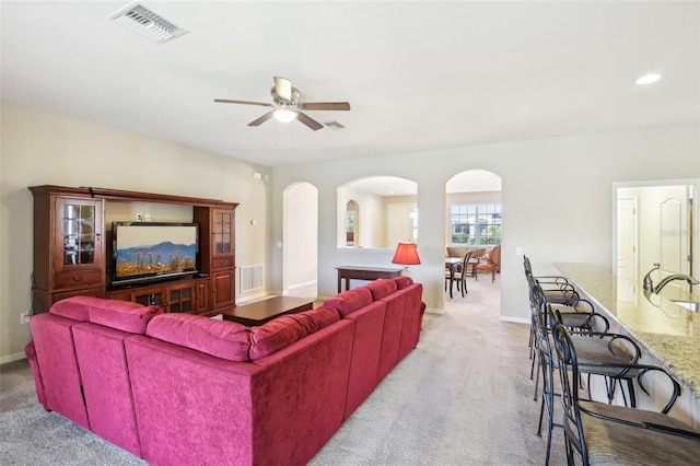 living room with light carpet and ceiling fan