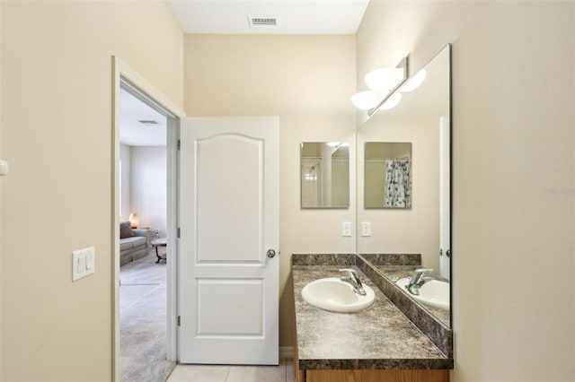 bathroom featuring tile patterned flooring, vanity, and curtained shower