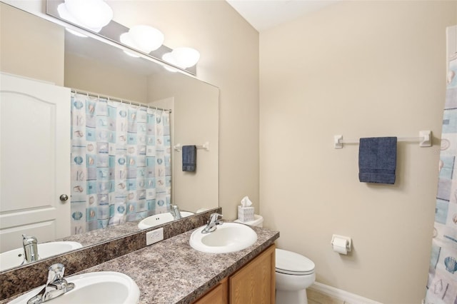 bathroom featuring vanity, toilet, and curtained shower