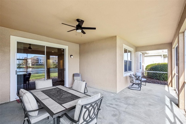 view of patio featuring a water view and ceiling fan