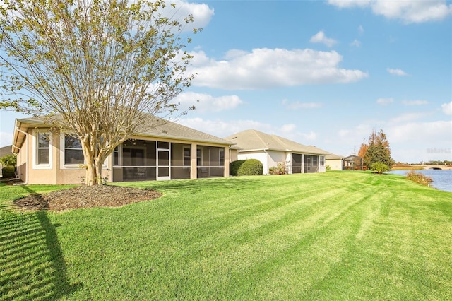 rear view of property with a lawn, a sunroom, and a water view