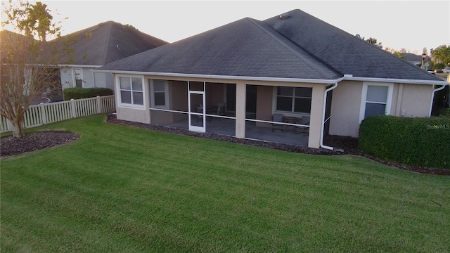 back of house with a lawn, a patio area, and a sunroom