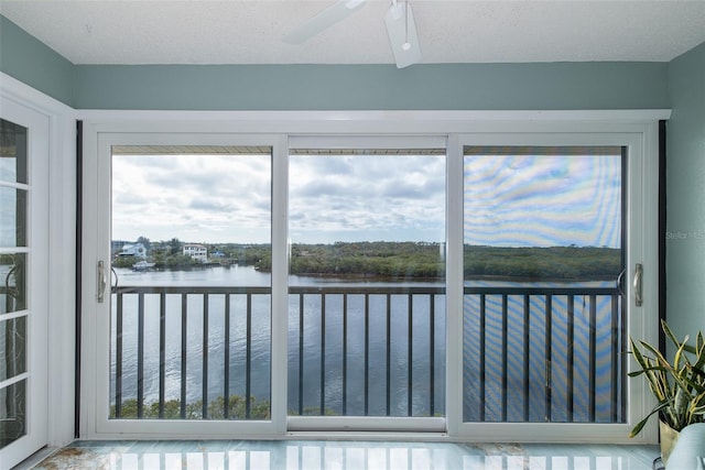 sunroom / solarium with ceiling fan and a water view