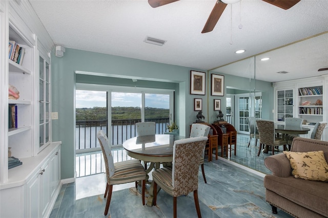 dining space with a textured ceiling, ceiling fan, and built in features