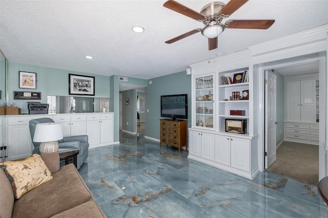 living room featuring a textured ceiling and ceiling fan