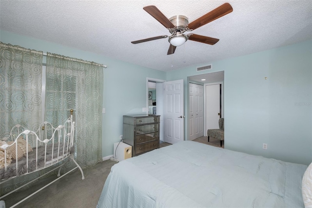 carpeted bedroom featuring a textured ceiling and ceiling fan