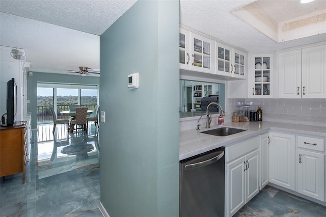 kitchen with dishwasher, tasteful backsplash, white cabinets, ceiling fan, and sink